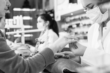 Nail masters performing manicure and massage in beauty salonの写真素材