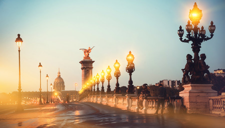 View of Hotel of Invalides from bridge of Alexandre III across Seine river in Paris with light trails of cars in early morningのeditorial素材