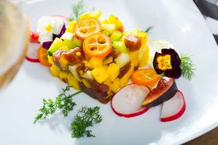 Raw tuna tartare with mango and avocado garnished with figs, kumquat and heartsease flowersの写真素材