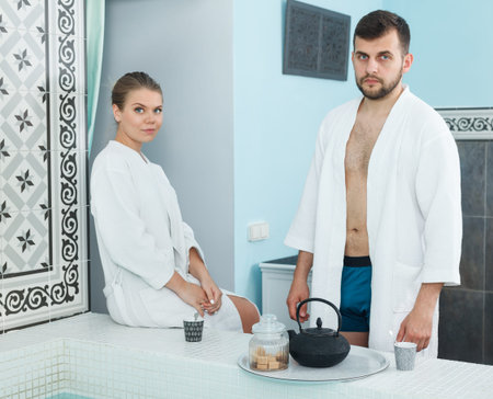 Loving couple drinking tea during wellness weekend in spa center. Focus on manの写真素材