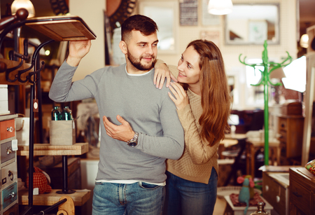 Loving couple looking for hallstand in shop of secondhand furnitureの写真素材