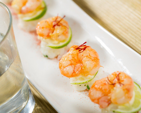 Grilled shrimps on rice balls with lime and saffronの写真素材