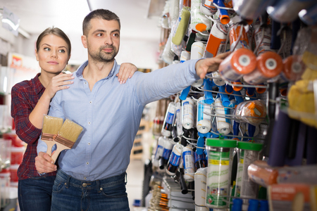 couple  with brushes choosing roller for repair house in the store.の写真素材