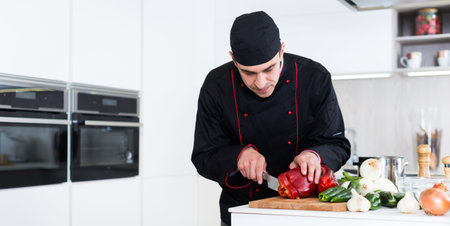Professional chef  in black uniform preparing vegetables on kitchen  indoor
