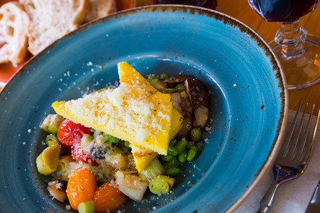 Delicious mushrooms served with baked vegetables and cheese on plateの写真素材