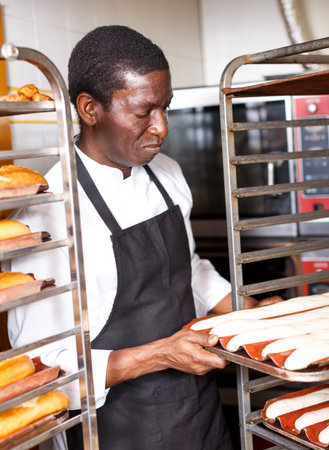 Portrait of experienced professional baker during daily work in kitchen of small bakeshop