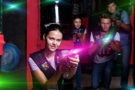 Lucky girl with laser guns  took aim and having fun with friends during laser tag gameの写真素材