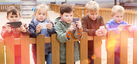 Five kidsare chatting on their smartphone