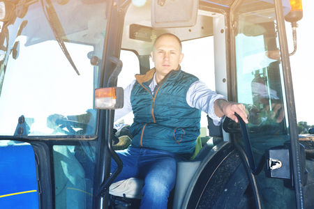 Portrait of handsome man working in vineyard sitting in tractor cabの写真素材