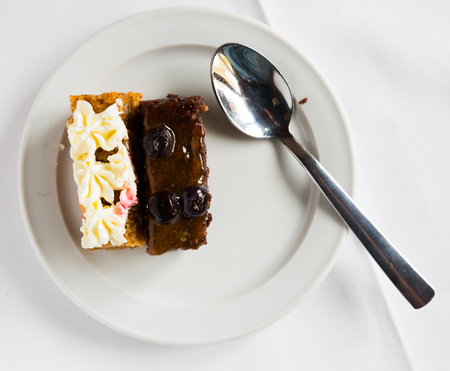 Image of sweet  sponge cake with chocolate and caramel served at plate with spoonの写真素材