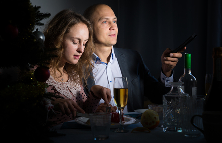 Wife and husband are watching TV on Christmas nightの写真素材