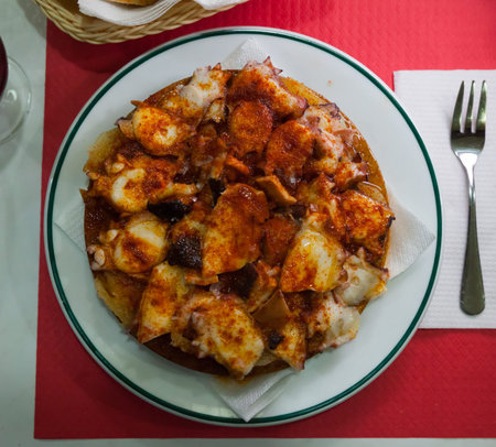 Traditional Galician fair dish of boiled octopus served with sliced cooked potatoes, smoked paprika and olive oil (Pulpo a la gallega)の写真素材