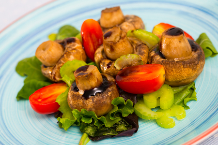 Delicious  baked champignons marinated in soy sauce with balsamic,  served with vegetablesの写真素材