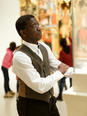 African man looking at exhibit on exposition of historical museumの写真素材