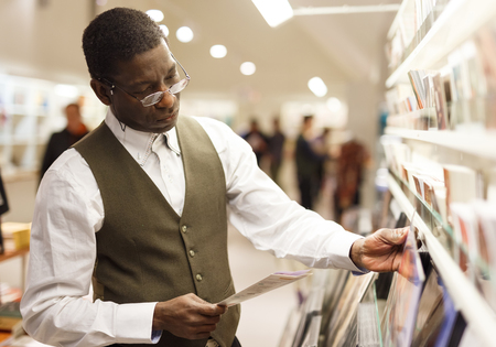 Portrait of handsome African-American man looking at souvenir products in shop at Art Museumの写真素材