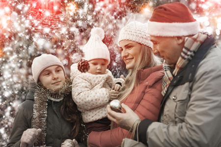 Portrait of cheerful man and woman with their happy daughters near counter buying Christmas decorationsの写真素材