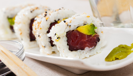 Image of tasty uramaki sushi with raw tuna fish and fresh avocado served at plateの写真素材