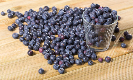 Heap of fresh blueberries scattered on wooden surface