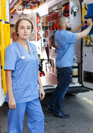 Portrait of cross-armed female emergency doctor near ambulance autoの写真素材