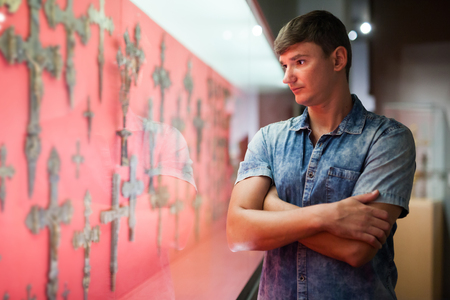 Man looking at stands with exhibits in historical museum hallの写真素材
