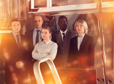 Toned image of international group of businesspeople confidently posing together in escape room stylized under laboratory. Successful business team conceptの写真素材