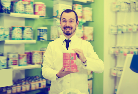Adult male pharmacist suggesting useful drug in pharmacyの写真素材