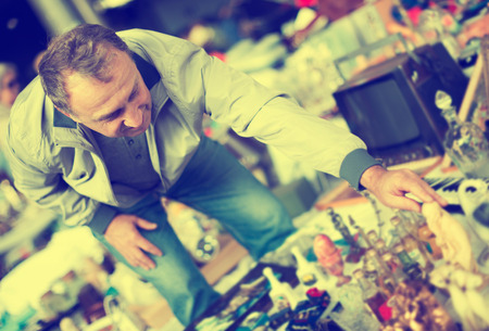 Adult male is visiting the market of old things and shopping outdoorsの写真素材