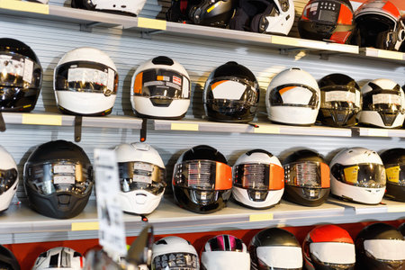 Interior of stylish moto salon with colorful motorcycle helmets on shelves