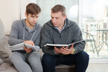Father and son decide school assignmentsの写真素材