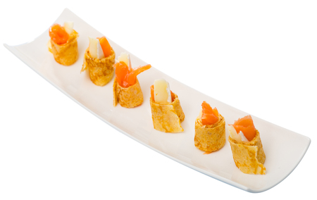 Pancakes rolls with salted salmon on a plate. Isolated over white backgroundの写真素材