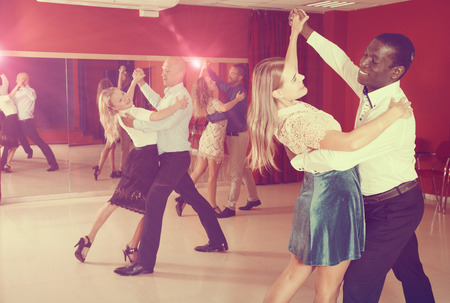 Young smiling people learning to dance waltz in dancing classの写真素材