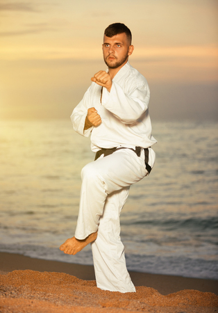 Positive man doing karate at ocean quay outdoorの写真素材