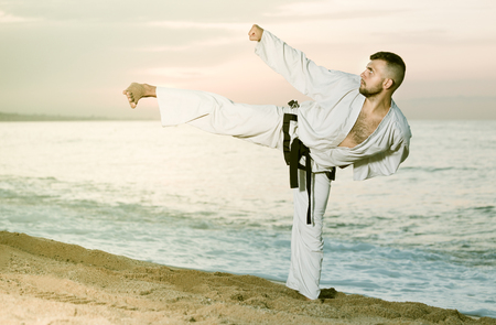 Male is training kick on the beach near the sea.の写真素材