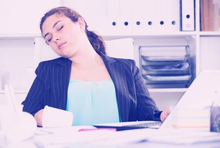 Office manager woman is sleeping at work after putting the reports in the office.の写真素材