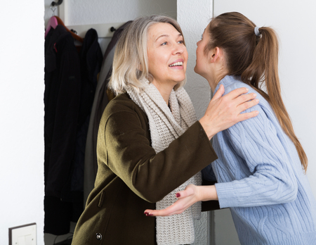 Daughter meets mother in the hallway at homeの写真素材