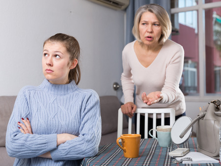Portrait of offended girl turned away from her mature motherの写真素材