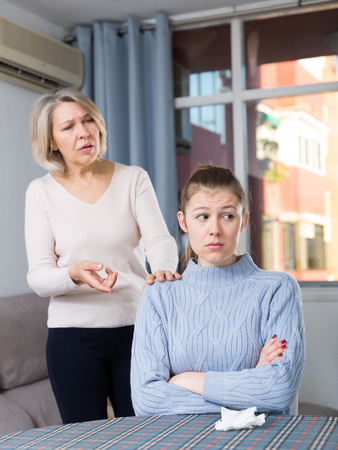 Sad daughter and unhappy senior mother quarrelling at homeの写真素材