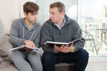 Father and son decide school assignmentsの写真素材