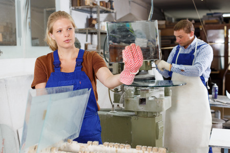 Portrait of qualified female glazier during daily work in glass factoryの写真素材