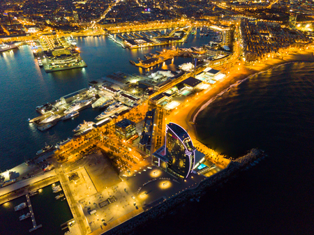 BARCELONA, SPAIN - MARCH 07, 2019: View from drone of illuminated Barceloneta beach with Port Vell and luxury hotel W Barcelona at nightのeditorial素材