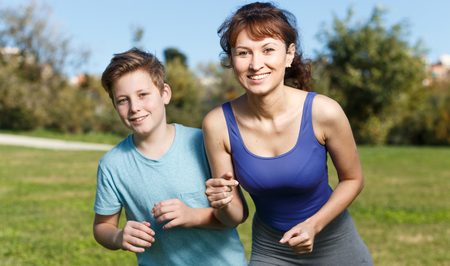 Mother and teen boy jogging during morning fitness workoutの写真素材