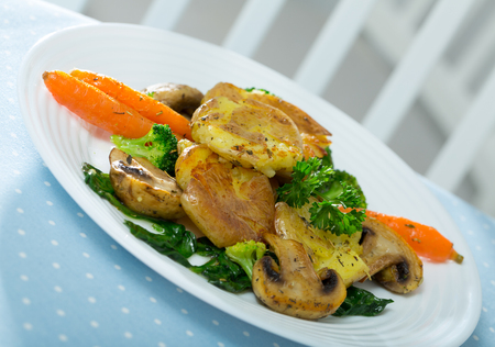 Dish of  australian cuisine, crash hot potatoes with mushrooms and vegetables at plateの写真素材