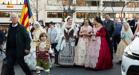 VALENCIA, SPAIN - MARCH 18, 2019: Falleres in colorful historic dresses parading through city streets during traditional Falles celebrationのeditorial素材