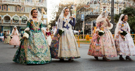 VALENCIA, SPAIN - MARCH 18, 2019: Falleres in colorful historic dresses parading through city streets during traditional Falles celebrationのeditorial素材