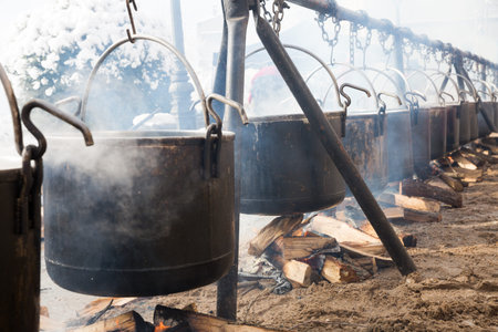 View of iron cauldrons for cooking outdoors in medieval style in open fire