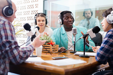 Scandal interview. Two outraged guests answering provocative questions of  smiling radio hosts  during live radio showの写真素材