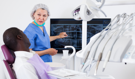Doctor woman dentist shows patient an x-rayの写真素材