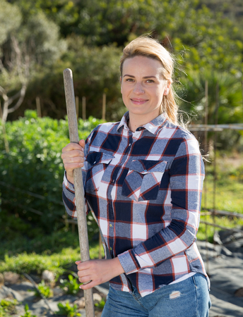 Female supervising growth of legume plants in gardenの写真素材