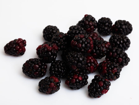 Close up of fresh blackberries on white surface