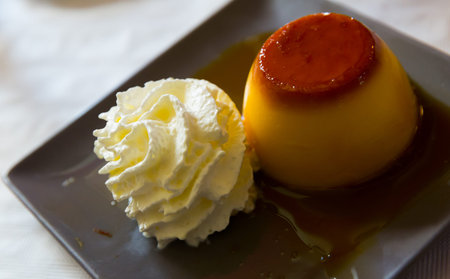 Tasty sweet custard flan with air whipped cream and caramel topping